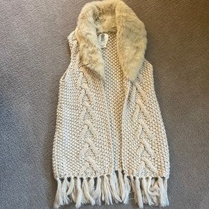 Sleeveless knit sweater vest w/faux fur collar.